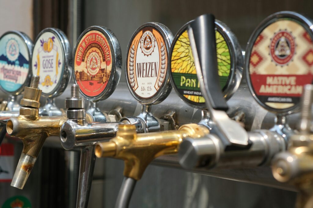 Close-up of craft beer taps with diverse labels in a bar setting. Ideal for beverages and brewery themes.
