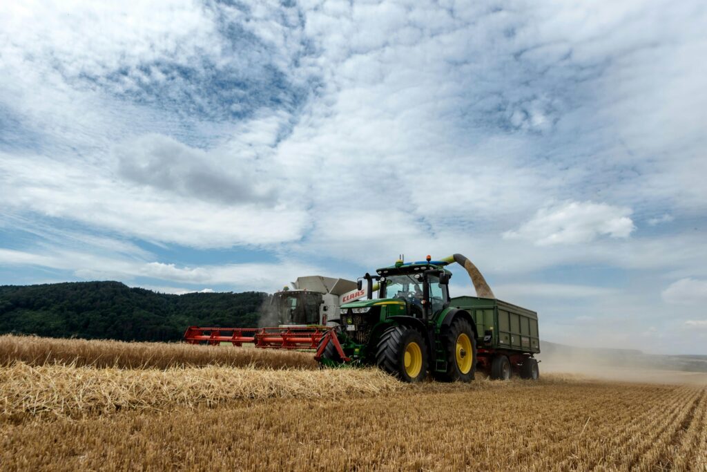 Combine harvester working in a wheat field under a clear sky in Höxter, Germany.